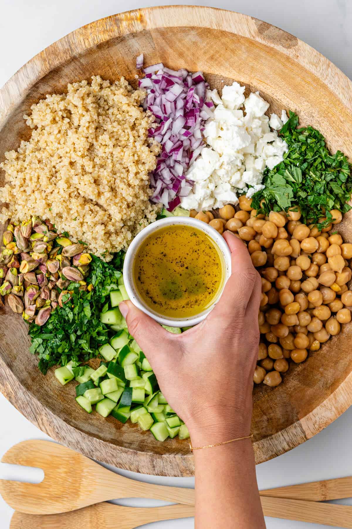 Dressing about to be poured over salad ingredients in a bowl
