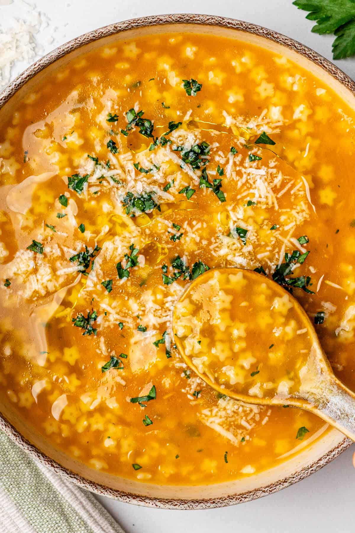 Pastina soup in a bowl with a spoon to show the texture of the pastina shape