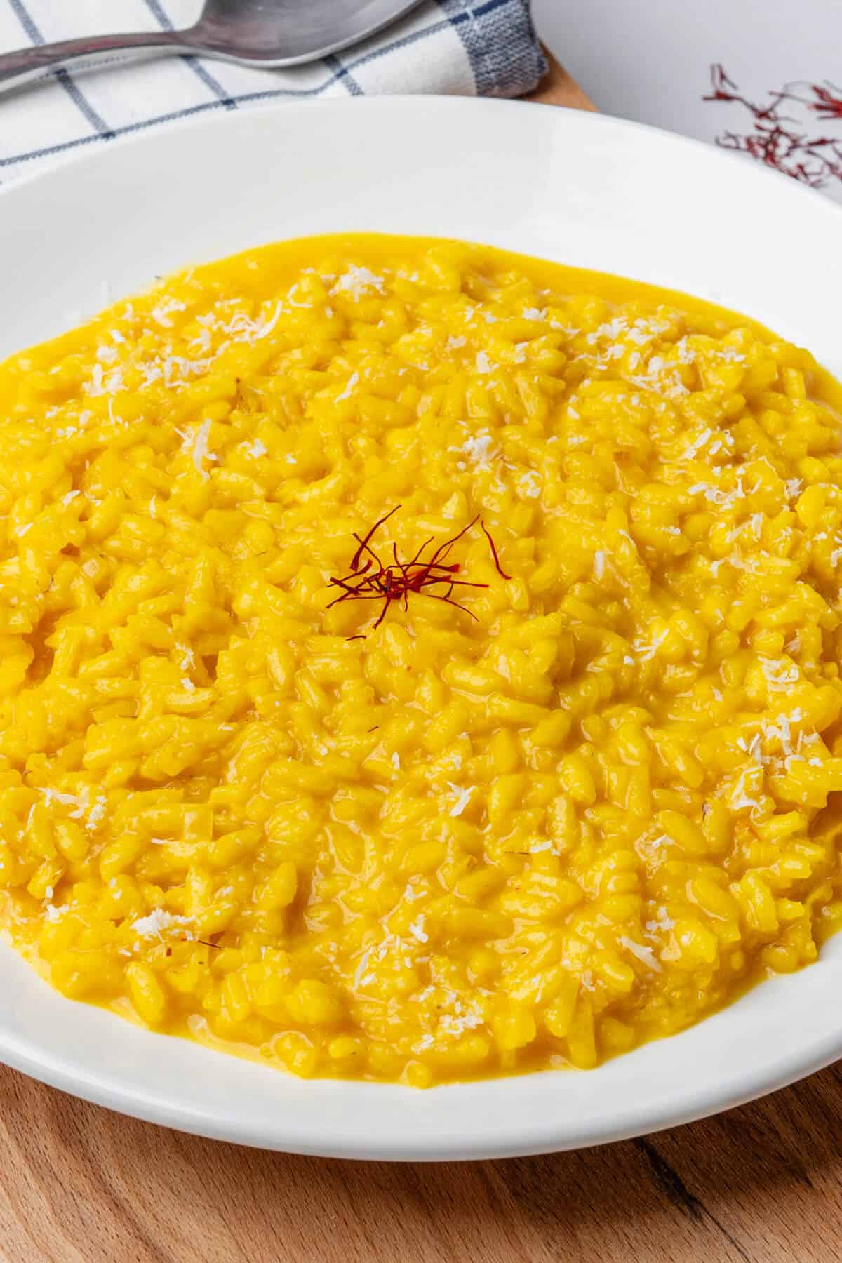 Bowl of saffron risotto with parmesan and saffron for garnish