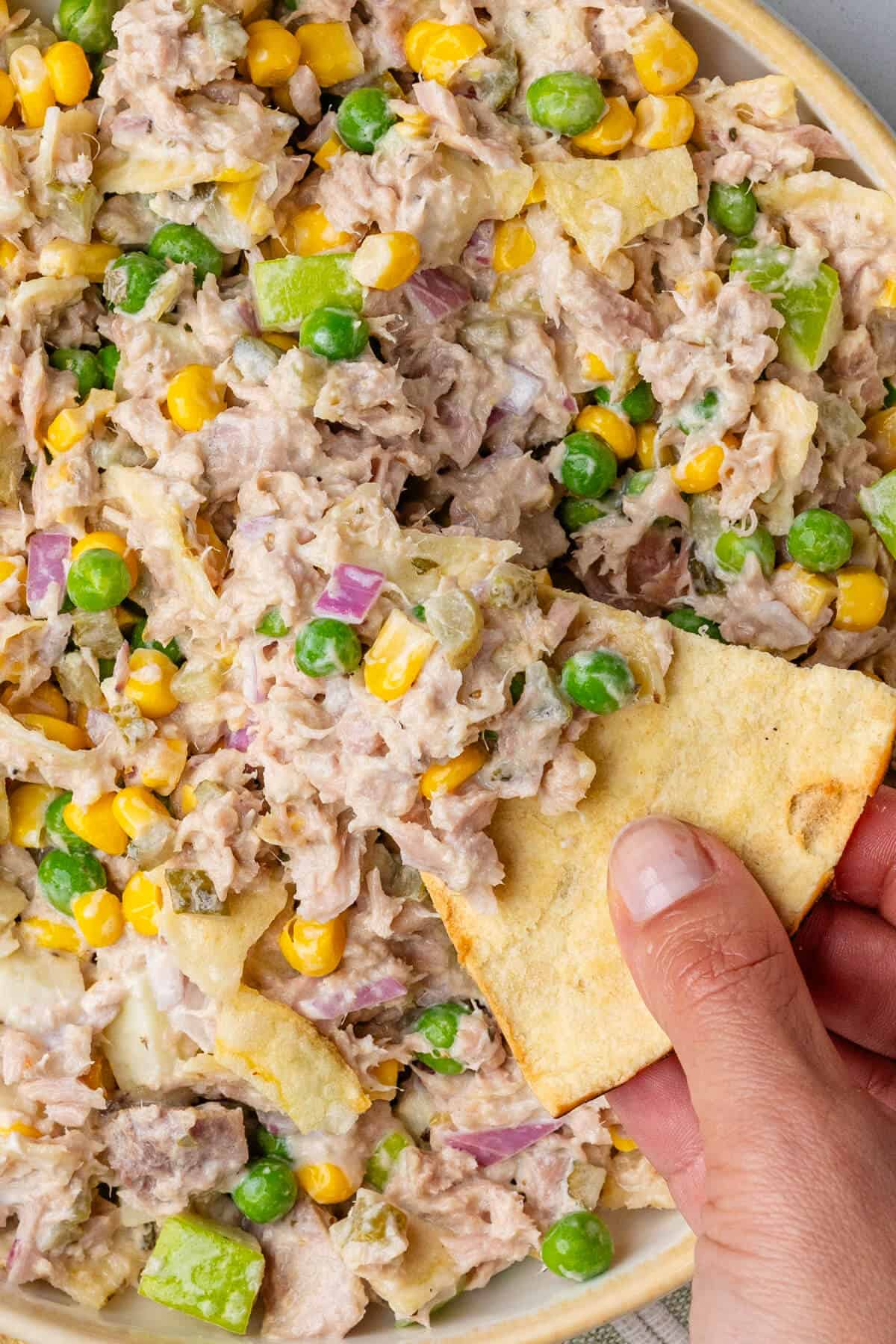 Close up of pita chip dipped into Matthew McConaughey Tuna Salad